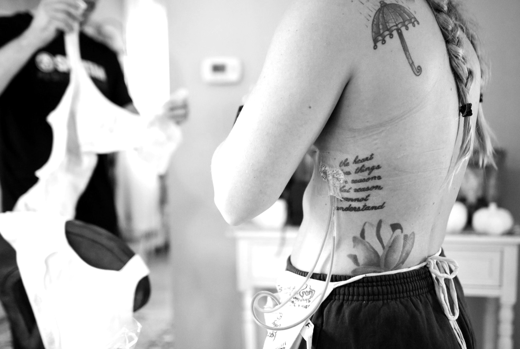 A fitter holding up a post-surgical bra for a woman during a fitting
